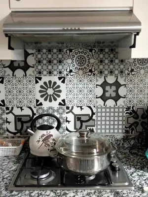 a kitchen with black and white tiles on the wall at Appartement Confort & Style à Charaf - Marrakech in Marrakech