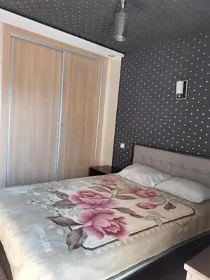 a bedroom with a bed with pink flowers on it at Appartement Confort & Style à Charaf - Marrakech in Marrakech