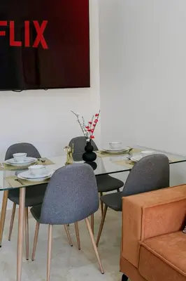 a dining room with a glass table and chairs at Suite Art déco Piscine privée in Marrakech