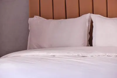 a bed with white sheets and pillows at Modern 3BR Apartment 5 Min from Majorelle Garden in Marrakech