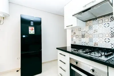 a kitchen with a stove and a black refrigerator at Migdal Jaouhara in Marrakech
