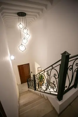 a staircase with a black railing and a chandelier at Duplex Majorella in Marrakech