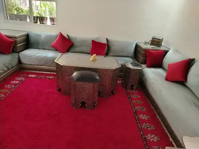 a living room with a couch and a red rug at Joli et affordable appart pas loin de l'aéroport in Oulad Akkou