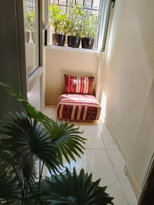 a room with a bench sitting under a window with potted plants at Joli et affordable appart pas loin de l'aéroport in Oulad Akkou