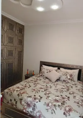 a bedroom with a bed with flowers on it at Joli et affordable appart pas loin de l'aéroport in Oulad Akkou