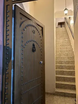 a wooden door in a hallway with stairs at Dar DAROUNE in Marrakech