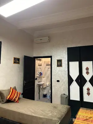 a bedroom with a bed and a bathroom with a sink at Dar DAROUNE in Marrakech