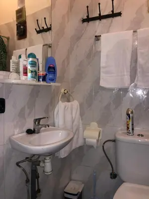 a bathroom with a sink and a toilet and towels at Dar DAROUNE in Marrakech