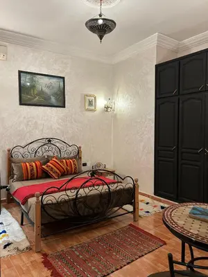 a bedroom with a bed with red pillows on it at Dar DAROUNE in Marrakech