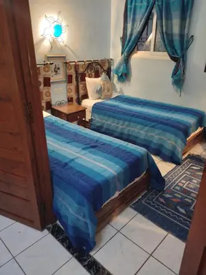 a bedroom with two beds with blue sheets at Riad avec jardins et piscines in Marrakech