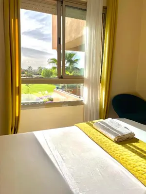 a bedroom with a bed and a window with a view at Prestigia golf in Marrakech