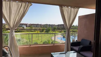a room with a large window with a view of a pool at Prestigia golf in Marrakech