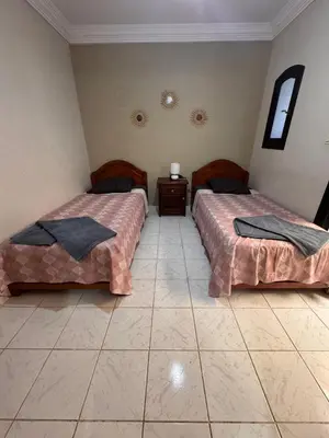 a room with two beds and a tiled floor at Riad Naïel piscine privée in Marrakech