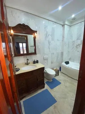 a bathroom with a sink and a tub and a toilet at Modern Gueliz Apartment with Private Pool, Near to Train Station in Marrakech