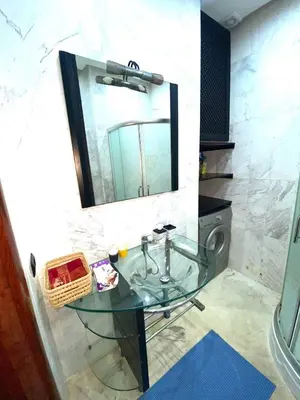 a bathroom with a glass sink and a mirror at Modern Gueliz Apartment with Private Pool, Near to Train Station in Marrakech