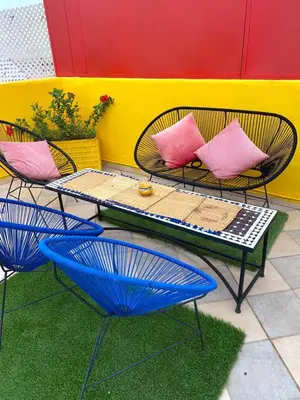 a patio with two chairs and a table with pink pillows at Modern Gueliz Apartment with Private Pool, Near to Train Station in Marrakech