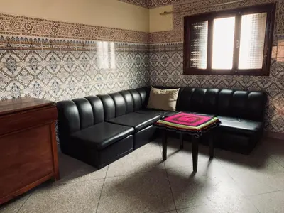 a black leather couch in a room with a table at 120m2, Centre Marrakech, Traditional in Marrakech