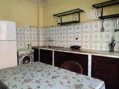 a kitchen with a table and a stove and a refrigerator at 120m2, Centre Marrakech, Traditional in Marrakech