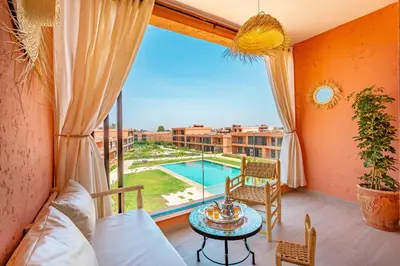 a room with a view of a pool and a table at Évasion à NORIA - Vue Piscine et Charme Local in Marrakech