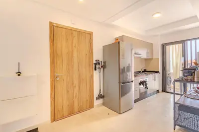a kitchen with a wooden door and a refrigerator at Évasion à NORIA - Vue Piscine et Charme Local in Marrakech