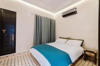 a bedroom with a bed with a blue blanket at Riad Emeraude Cozy Riad with Shared Pool 4 Room in Marrakech