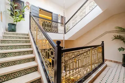 a staircase with ornate metal railings in a house at Riad Emeraude Cozy Riad with Shared Pool 4 Room in Marrakech