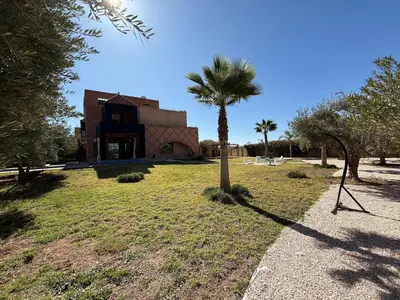 a building with a palm tree in front of it at Prestigious Villa in Marrakesh in Marrakech