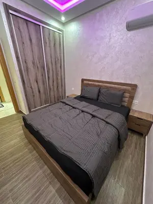 a bedroom with a large bed with a purple ceiling at Appartement cozy in Marrakech