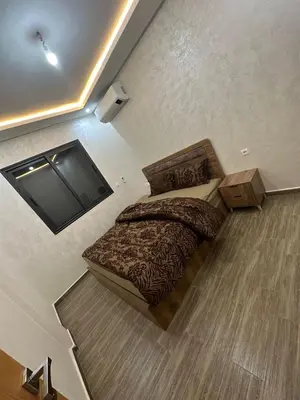 a bedroom with a bed and a television on the floor at Appartement cozy in Marrakech