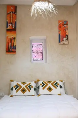a bedroom with a bed with two pillows and a window at dar dmana in Marrakech