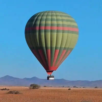 a hot air balloon flying over the desert at Qortoba house in Marrakech