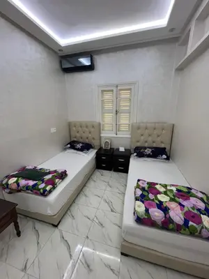 two beds in a room with white walls at Qortoba house in Marrakech