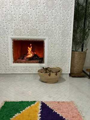 a fireplace in a living room with a fire place at Riad de luxe PAMA au cœur de la médina Marrakech in Marrakech