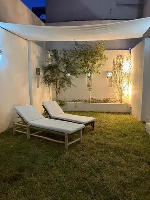 two beds sitting on the grass under a tent at Riad de luxe PAMA au cœur de la médina Marrakech in Marrakech