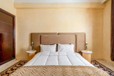 a bedroom with a large bed with two tables at Cocon De Luxe Proche du Centre in Marrakech