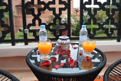 a table with two glasses and bottles of orange juice at Golden Palms Marrakech in Marrakech