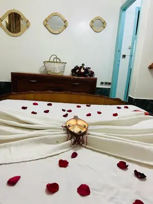 a bed with red rose petals on the sheets at Les 3 SOEURS MAJORELLE in Marrakech