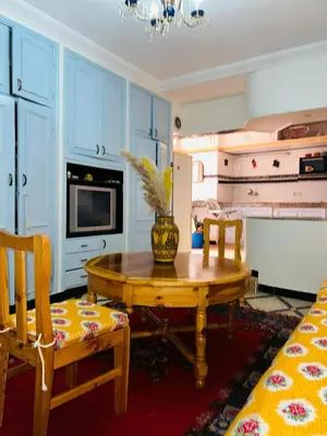 a kitchen with a wooden table and a dining room at Les 3 SOEURS MAJORELLE in Marrakech