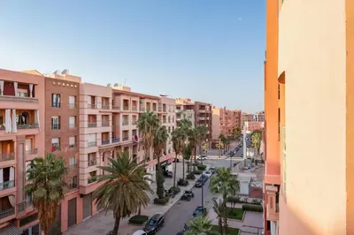 a city street with palm trees and buildings at Cosy and fully equipped 2bed appt in Gueliz in Marrakech
