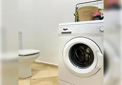 a bathroom with a washing machine and a toilet at Ehden Properties - Appt spacieux dans la prestigieuse River Palm Marrakech in Marrakech