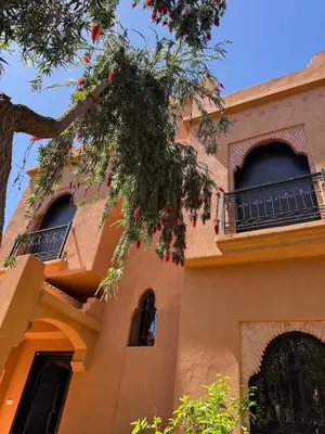 a building with a tree in front of it at Magnifique Villa piscine chauffée, cinéma et salle de fitness privés in Marrakech