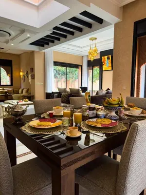 a table with food on it in a living room at Magnifique Villa piscine chauffée, cinéma et salle de fitness privés in Marrakech