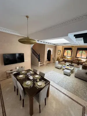 a large living room with a table and chairs at Magnifique Villa piscine chauffée, cinéma et salle de fitness privés in Marrakech