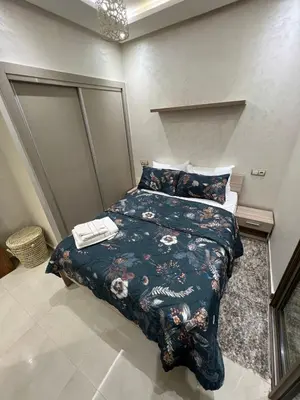 a bedroom with a bed with a blue comforter at Cozy and convenient apartment in Marrakech