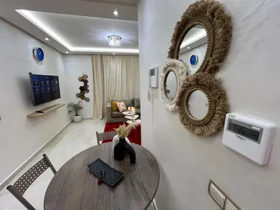 a living room with a table and a mirror at Cozy and convenient apartment in Marrakech