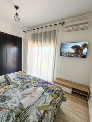 a bedroom with a bed with a tv on the wall at Villa Oasis Marrakesh in Marrakech