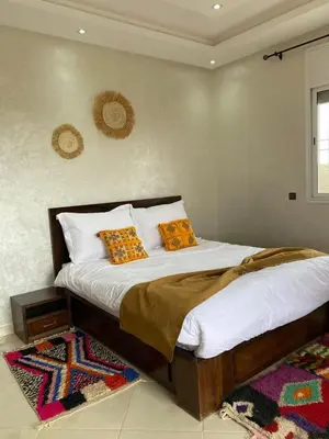 a bedroom with a bed with white sheets and orange pillows at Espace Dar Es Saadâ in Marrakech