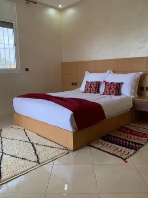 a bedroom with a large bed with red pillows at Espace Dar Es Saadâ in Marrakech