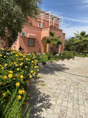 a pink building with yellow flowers in front of it at Espace Dar Es Saadâ in Marrakech