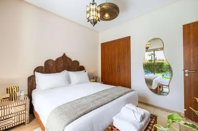 a bedroom with a large bed and a mirror at Charme Marrakchi - Piscine, Jardin & Espace Sport in Marrakech